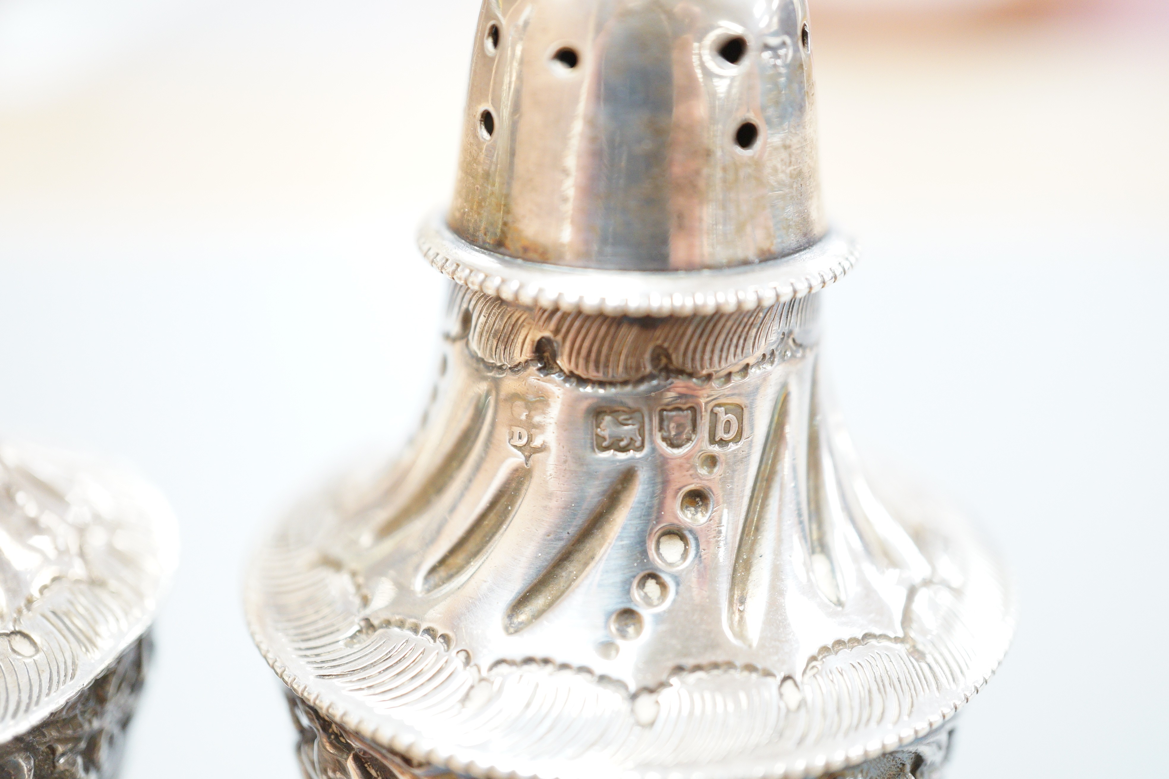 A pair of late Victorian silver vase shaped pedestal pepperettes, by Josiah Williams & Co, London, 1897, 10.5cm, 120 grams.